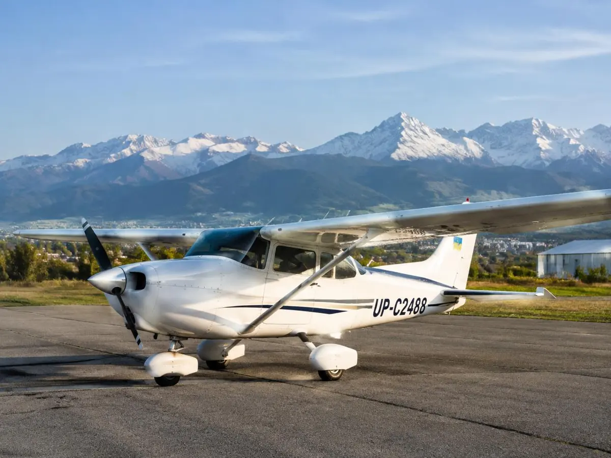 Light aircraft on the apron near Almaty with mountains behind